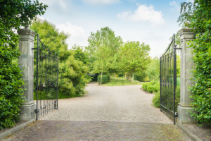 Wrought iron gate opening to estate home driveway